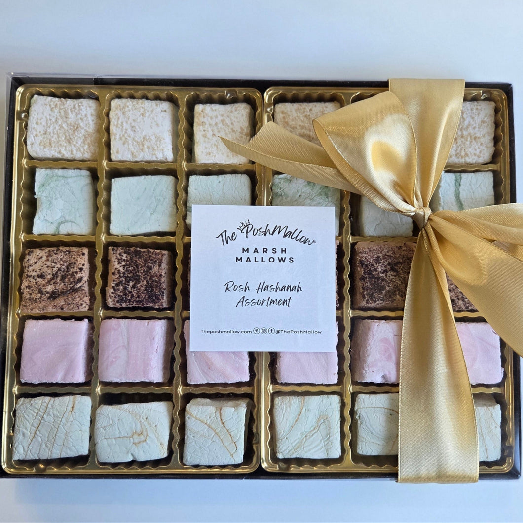 Box of assorted marshmallows with a gold ribbon on a white background