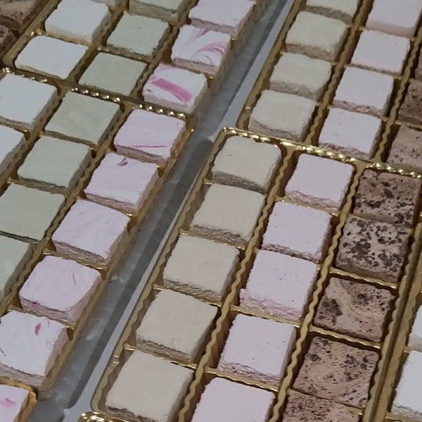 Close-up of small square tiles with different colors and patterns on a grid.