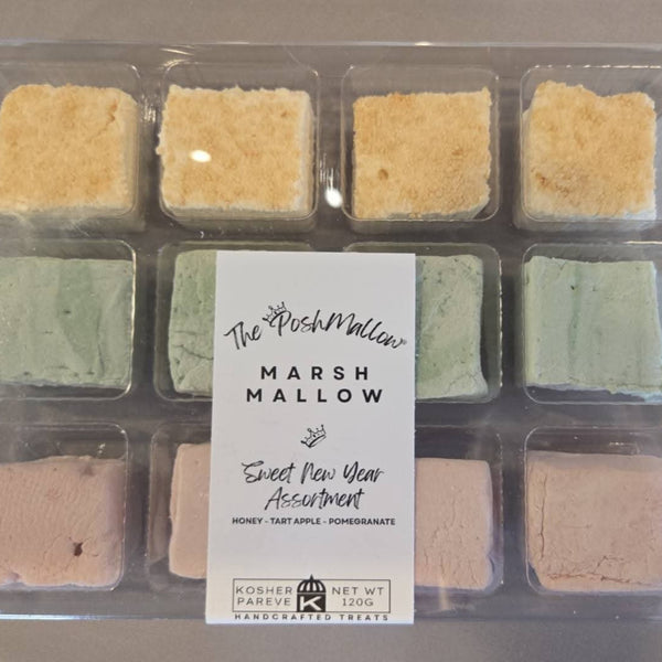 Assorted marshmallows in a clear packaging tray with a label on a gray background